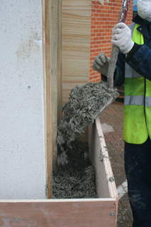 filling the shuttering with hemp-lime mix ready for tamping down