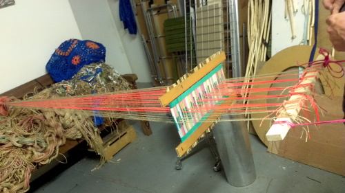 This homemade loom, which I made with my friend Shane Waltener from things we could find in his studio is a frame-less back-strap loom, which we have improvised a Scandinavian style fixed heddle for out of straws, wooden kebab skewers and the slats from an old Venetian blind.