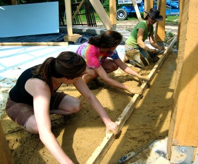 Levelling the adobe earthen floor with a long straight 2x4