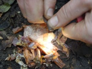 Demonstrating how firesteels are used to create a spark