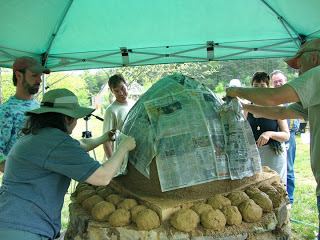 Adding a layer of newspaper to the cob oven shell