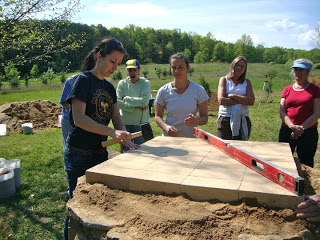 Laying the firebricks at the base of the cob oven