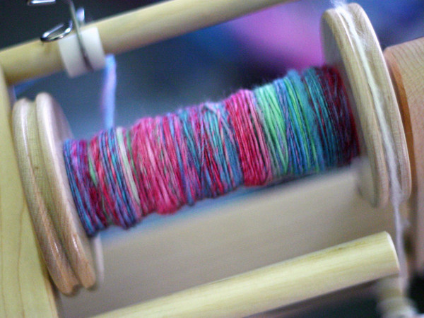 Close-up of spools of color threads, spinning machine. Yarn